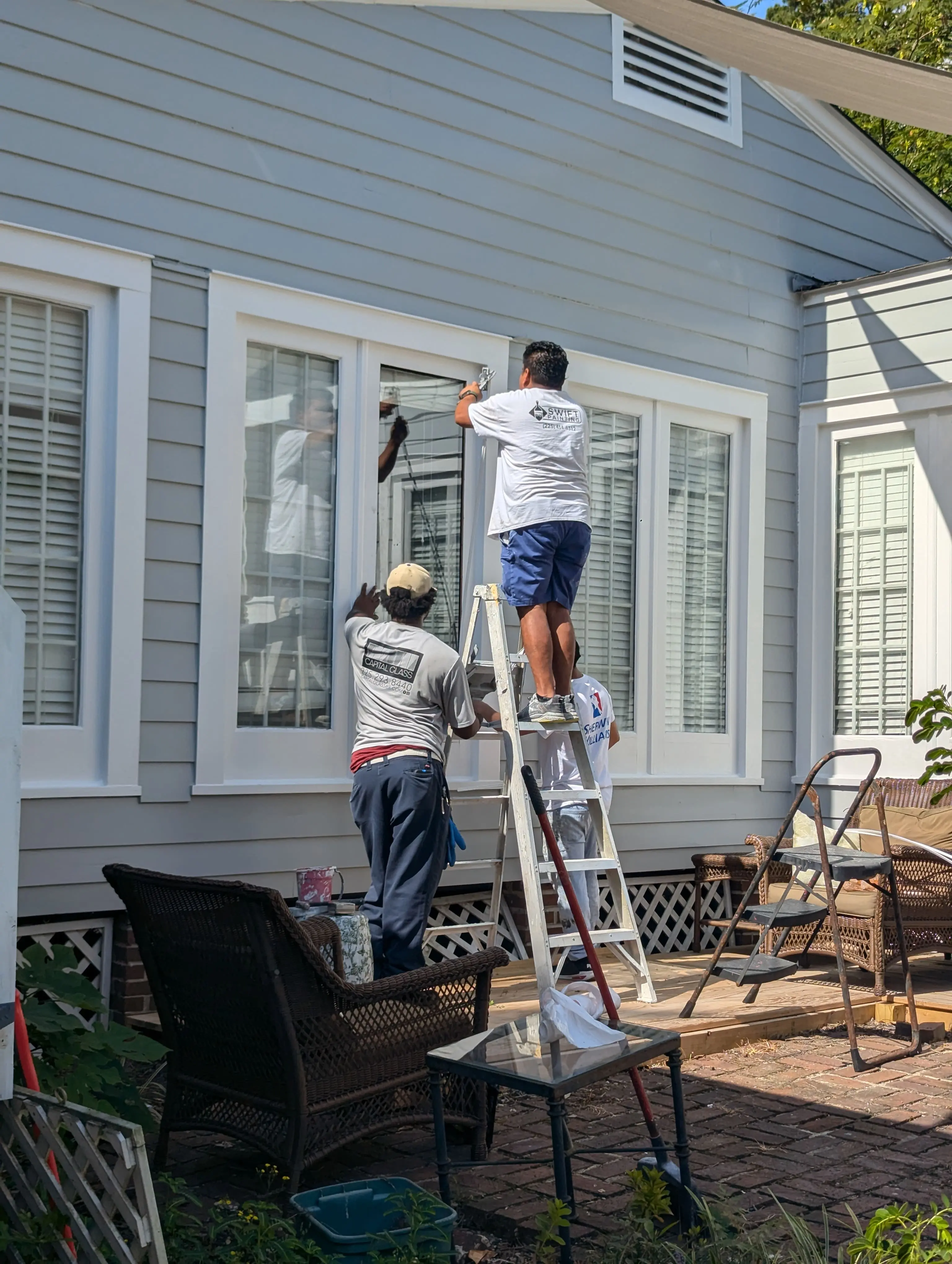 Swift Painting crew working efficiently on exterior trim and windows