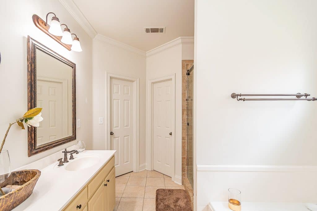 Brightly lit bathroom with freshly painted white walls and crisp crown molding.