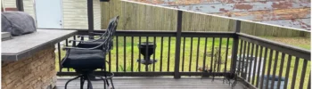 A split-screen comparison showing a severely weathered, peeling top deck contrasted with a finished lower patio area using solid dark grey and brown stains to completely hide wood flaws near an outdoor stone bar.